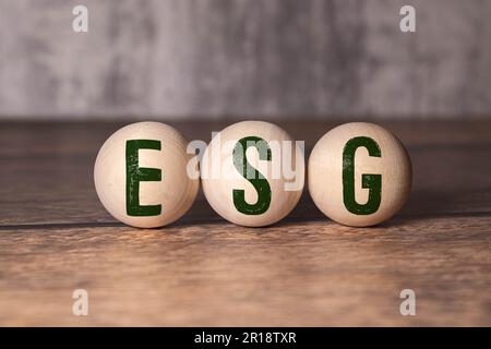 ESG - Environmental Social Governance - an abbreviation of wooden blocks with letters on a gray background. reflection of the caption on the mirrored Stock Photo
