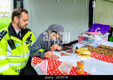 Artist applying henna tattoo on a Police Officer. Mehndi is traditional Indian decorative art Stock Photo