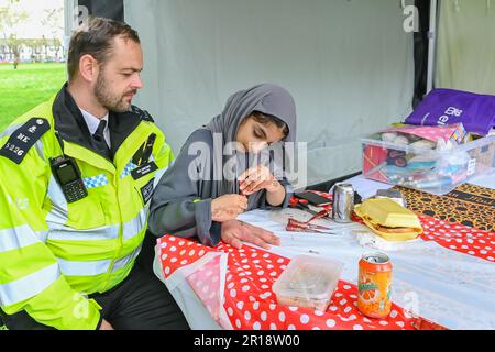 Artist applying henna tattoo on a Police Officer. Mehndi is traditional Indian decorative art Stock Photo