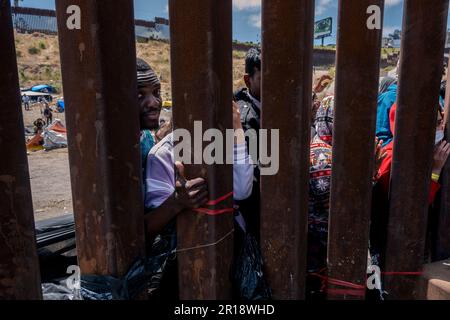 San Diego, USA. 11th May, 2023. An asylum-seeker looks through the border fence west of the San Ysidro Port of Entry on May 11, 2023. (Matthew Bowler/KPBS/Sipa USA) **NO SALES IN SAN DIEGO-SAN DIEGO OUT** Credit: Sipa USA/Alamy Live News Stock Photo