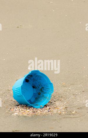 empty lone bucket left unattended on sand at the beach, pollution, litter, lost toy Stock Photo