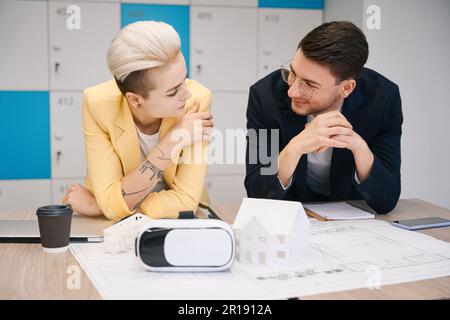 Developers smiling, looking at paper house layout Stock Photo