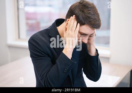 Man is massaging sore temples, feeling headache Stock Photo
