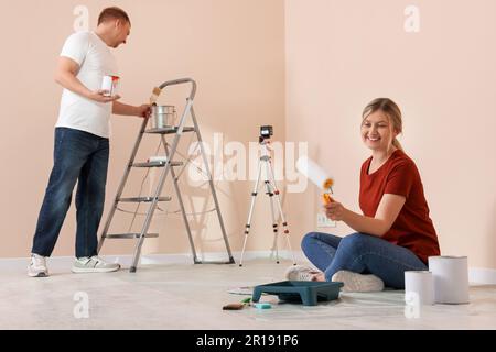 Happy couple with painting tools in apartment during repair Stock Photo