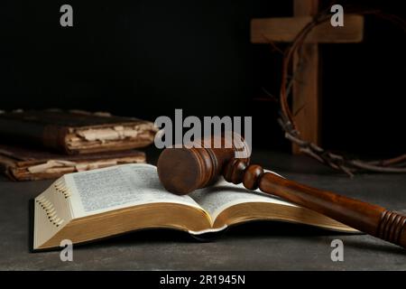 Judge gavel, bible, wooden cross and crown of thorns on grey table ...