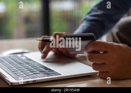 man hands holding credit card using internet payment laptop computer, online shopping digital banking, Business financial technology concept. Stock Photo