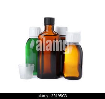 Bottles of syrups with measuring cups on white background. Cough and cold medicine Stock Photo