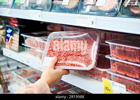 Minced meat in the hands of the buyer in the store Stock Photo