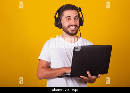 Happy Latin American Brazilian man holding notebook and smiling, with headset, telemarketing worker concept Stock Photo
