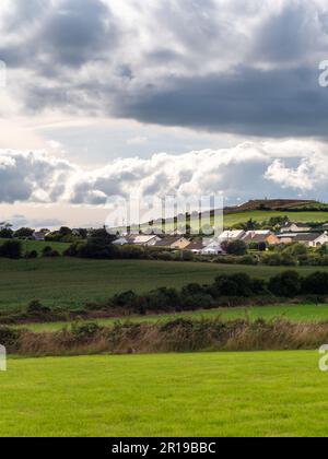 Sky with cumulus clouds over a small Irish village on a summer evening. Irish settlement in County Cork, dramatic landscape. European countryside, rus Stock Photo