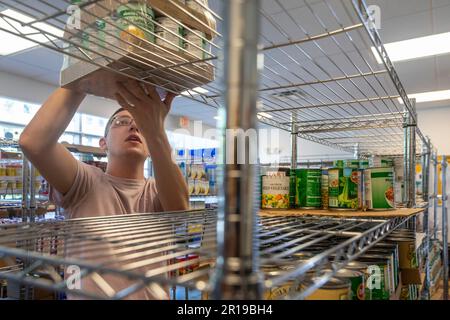 Detroit, Michigan - Student employee Ethan Cassatt stocks the shelves at the Wayne State University food pantry. Although open to anyone, the food pan Stock Photo