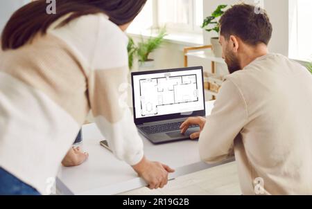 Two architects or interior designers working with design project of new apartment on a laptop. Stock Photo