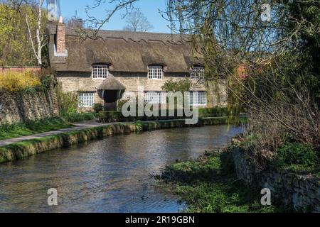 Beck Isle thatched cottage beside Thornton Beck in spring, Thornton le Dale, near Pickering, North Yorkshire Stock Photo