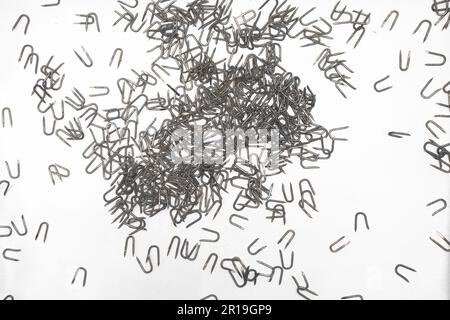 scattered heavy barbed wire staples materials for construction and carpentry on white background Stock Photo