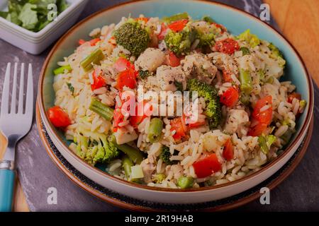 Healthy meal of chicken with rice and vegetables and garnished with seasoning and herbs. Stock Photo