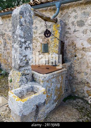Old well with bucket and trough in the Santuari de la Mare de Deu del Refugi in the Castell d'Alaro Tramuntana Majorca Stock Photo