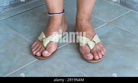 Woman wearing flip flops. Stylish woman wearing anklets and flip flops in summer. Summer holiday concept Stock Photo