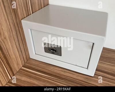 White iron small safe in the hotel room for storing valuables and money. Stock Photo