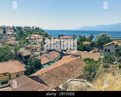 view from a height of a small settlement of local residents. small houses with tiled roofs. houses on a mountain hill with palm trees. Stock Photo