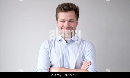 The young European man confidently looks into the camera and smiles Stock Photo