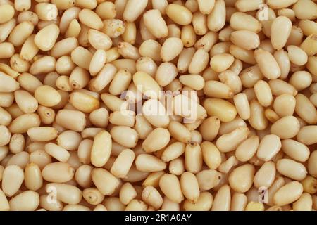 A pile of raw shelled pine nuts arranged randomly. View from above. Closeup Stock Photo