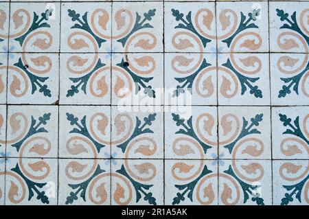 The texture of square ceramic tiles with patterns from traditional Arabic ornaments and flowers of yellow and blue with seams. The background. Stock Photo