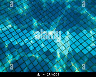 Beautiful texture of a small square ceramic tile with seams in a pool under blue water, underwater view in the pool, sea, ocean in a tropical seaside Stock Photo