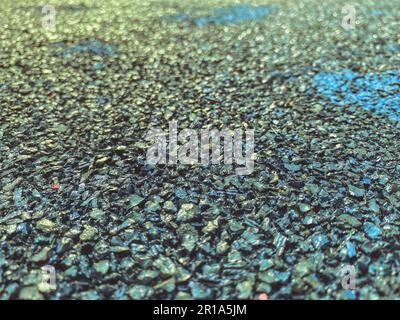 gray texture, stones of different colors. a background of small black, sharp stones that are tightly packed into the road. sports ground cover. Stock Photo