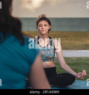 Two women meditating in the park Stock Photo