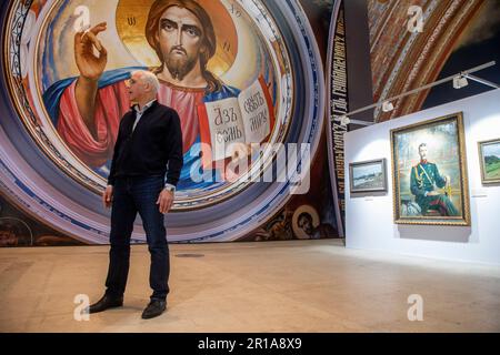 Moscow, Russia. 12th May, 2023. Artist Vasily Nesterenko at the exhibition of his works 'We are Russians, God is with us!' in the Central Exhibition Hall 'Manege' in Moscow, Russia. The exhibition presents reproductions of paintings by the artist of the Cathedral of Christ the Savior Stock Photo