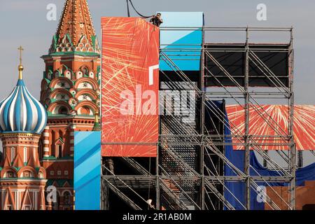 Moscow, Russia. 12th May, 2023. A worker disassembles a festive banner installed for the military parade and celebration on Victory Day May 9 on Red Square, against the background of St. Basil's Cathedral in the center of Moscow, Russia Stock Photo