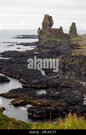 Black rocky cliffs in Iceland with water and horizon Stock Photo