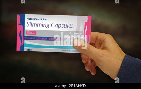 Slimming capsules box in hand. Weight fat loss and slim help pills