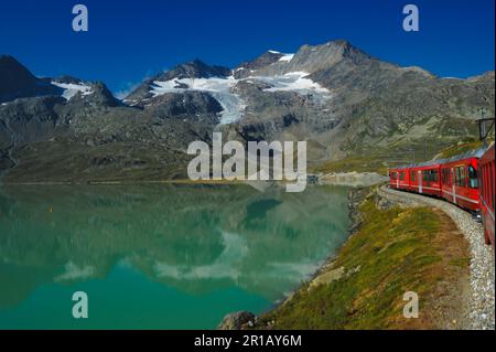 Sankt Moritz Switzerland May 13 2023: Little red train traveling in the Swiss mountains and connecting Switzerland with Italy Stock Photo