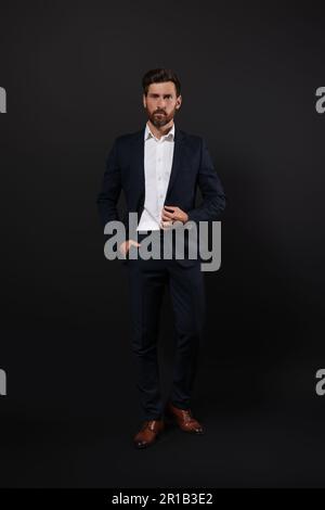 Handsome bearded man in suit on black background Stock Photo