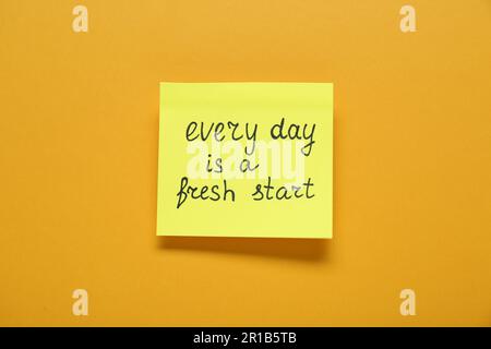 Note with phrase Every Day Is A Fresh Start on orange background, top view. Motivational quote Stock Photo