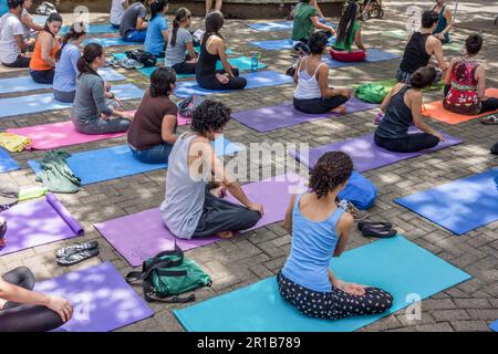Men and women sitting on pads at a yoga class in a park in San José, Costa Rica. Stock Photo