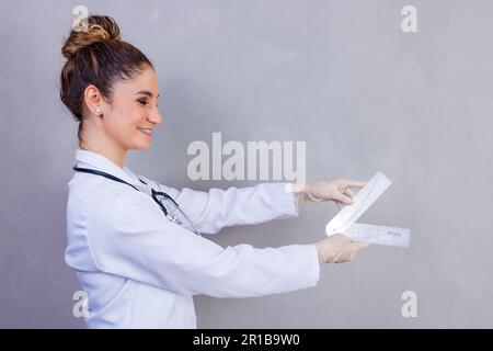 physiotherapist with a goniometry in grey background Stock Photo