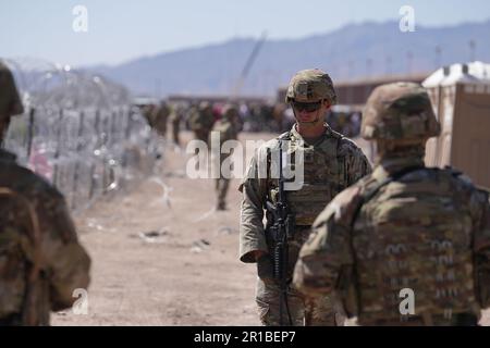 Members of the Operation Lone Star Task Force West and Texas Tactical Border Force block migrants from illegally entering Texas, May 11, 2023 near El Paso on the Rio Grande River. The units assumed blocking positions behind previously installed concertina wire in preparation for the expiration of Title 42. Stock Photo