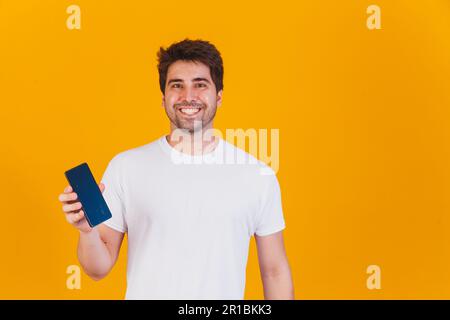 handsome man with cellphone in hands pointing with space for text Stock Photo