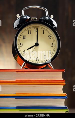 Composition with old black alarm clock on the stack of books Stock Photo