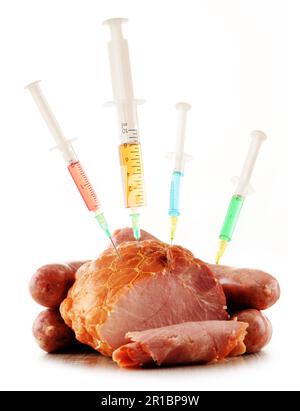 Syringes and meat isolated on white. Genetically modified food. GMO Stock Photo