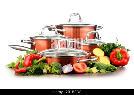 Set of pots and raw vegetables isolated on white background Stock Photo