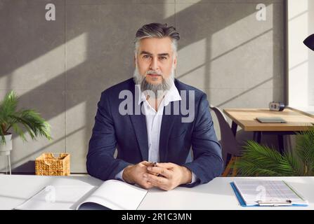 Businessman sitting at desk looking at camera having videocall online conversation Stock Photo