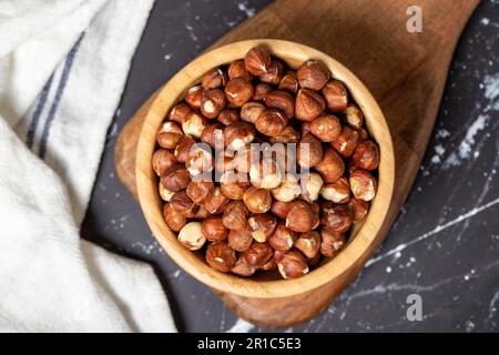 Hazelnut. Peeled hazelnuts in wooden bowl. Superfood. Vegetarian food concept. Healthy snacks. Top view Stock Photo