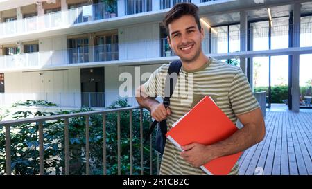 Portrait of caucasian male student at university campus looking at camera smiling during break-time. Stock Photo