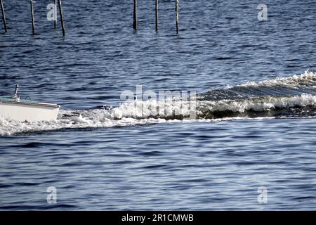 stern wave of a small boat on a lake Stock Photo
