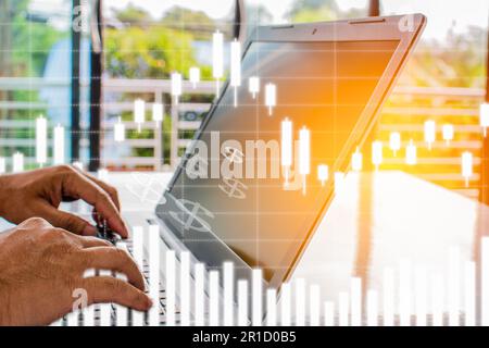 Hand of a businessman typing a notebook keyboard To analyze stock prices. A laptop screen is blank and blurry. Graph showing business performance. Wor Stock Photo