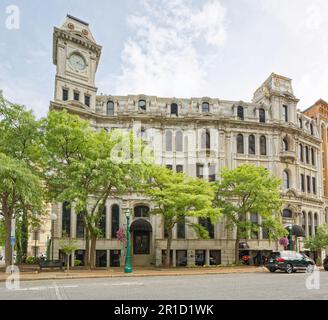 Gridley Building, originally Onondaga County Savings Bank Building, is a grey stone landmark with clock tower facing Clinton Square. Stock Photo