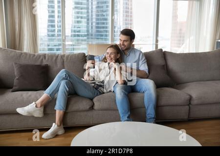 Happy young couple using mobile phone together Stock Photo